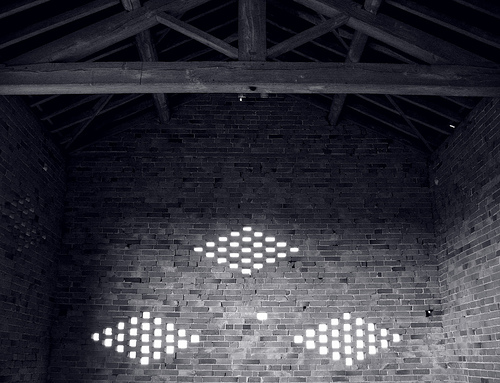 Interior of an old brick barn, illuminated by dove holes cut in the side of the walls, Meon Hill